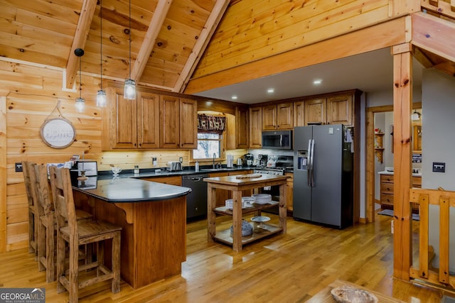 105 Ranch Mountain Ct, Dahlonega, GA 30533 - kitchen featuring stainless steel appliances, dark countertops, a peninsula, brown cabinets, and light wood-style floors