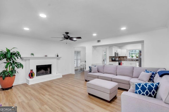 1481 Howard Way, Lawrenceville, GA 30043 - living room with recessed lighting, ceiling fan, light wood-style flooring, and a brick fireplace