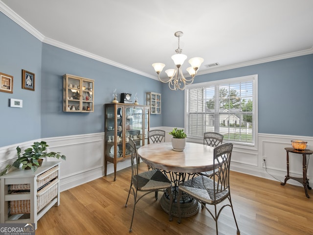 1804 Maxey Ln, Winder, GA 30680 - dining area featuring a chandelier, ornamental molding, wainscoting, and wood finished floors
