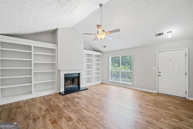 3997 Paloverde Dr NW, Kennesaw, GA 30144 - unfurnished living room featuring wood finished floors, a textured ceiling, ceiling fan, built in features, and lofted ceiling