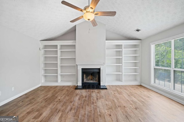 3997 Paloverde Dr NW, Kennesaw, GA 30144 - unfurnished living room with a textured ceiling, wood finished floors, lofted ceiling, ceiling fan, and built in shelves