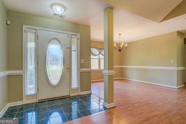 1615 Clairmont Ln SW, Conyers, GA 30094 - entrance foyer featuring a chandelier, decorative columns, wood finished floors, and a textured ceiling