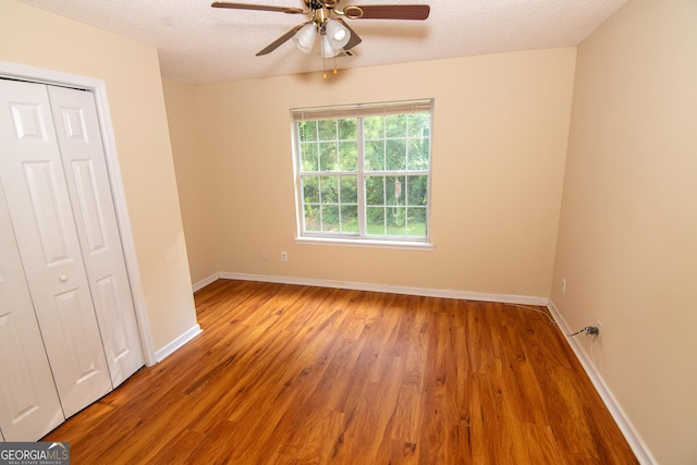 214 Hunters Chase, Byron, GA 31008 - unfurnished bedroom with wood finished floors, a closet, a textured ceiling, and ceiling fan