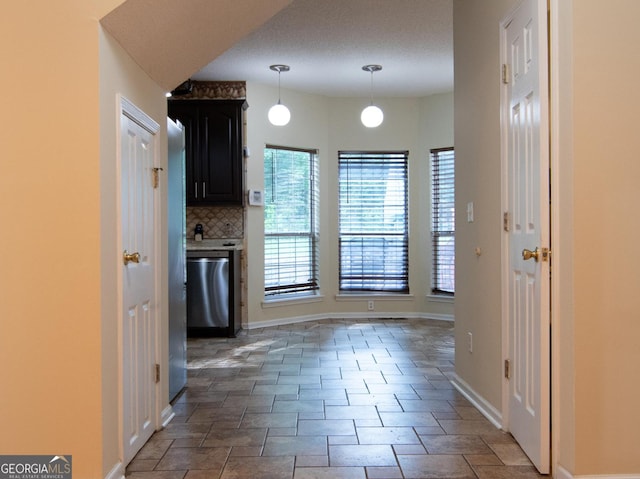 214 Hunters Chase, Byron, GA 31008 - kitchen featuring dishwasher, decorative backsplash, decorative light fixtures, light countertops, and dark cabinetry