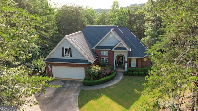 219 John Garner Rd, Dahlonega, GA 30533 - traditional home featuring brick siding, concrete driveway, an attached garage, a front lawn, and a forest view