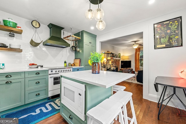 216 Leyden St, Decatur, GA 30030 - kitchen featuring green cabinetry, wall chimney range hood, gas range, white microwave, and light countertops