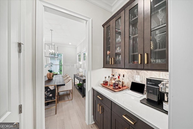 410 Anglin Walk, Alpharetta, GA 30009 - bar with ornamental molding, light wood finished floors, tasteful backsplash, a chandelier, and pendant lighting