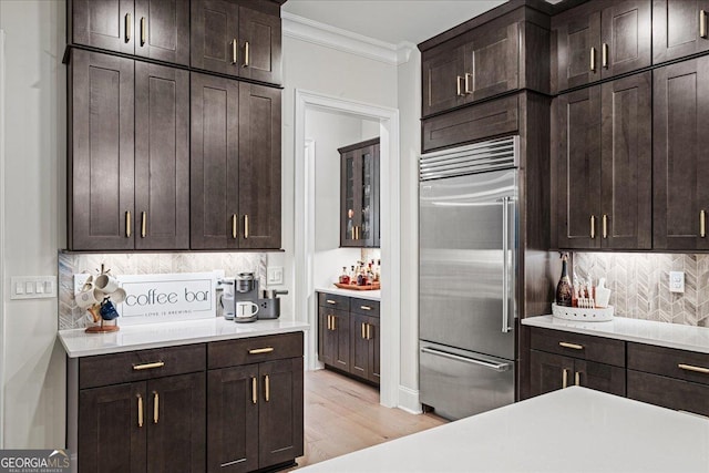 410 Anglin Walk, Alpharetta, GA 30009 - kitchen featuring built in fridge, crown molding, backsplash, dark brown cabinets, and light countertops