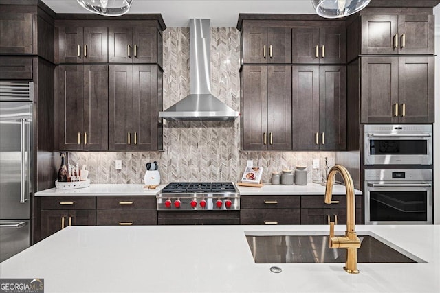 410 Anglin Walk, Alpharetta, GA 30009 - kitchen with wall chimney range hood, stainless steel appliances, light countertops, dark brown cabinetry, and tasteful backsplash