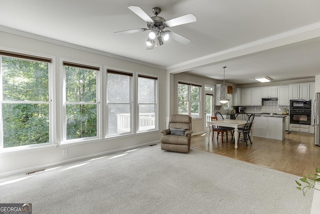 1614 Summersweet Ln, Dacula, GA 30019 - living area with light colored carpet, ornamental molding, and ceiling fan