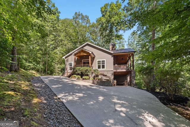 112 Springhill Ln, Clarkesville, GA 30523 - view of front of home with stone siding, a chimney, concrete driveway, covered porch, and a metal roof