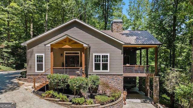 112 Springhill Ln, Clarkesville, GA 30523 - view of front of house featuring a metal roof, a chimney, stone siding, stairs, and covered porch
