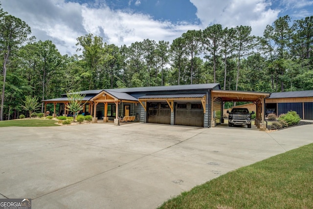 2591 Reids Ferry Rd, Buckhead, GA 30625 - view of front of house with concrete driveway, a metal roof, a garage, solar panels, and view of scattered trees