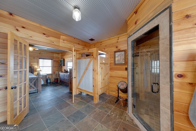 335 Jones Rd, Jefferson, GA 30549 - bathroom featuring wooden walls, a stall shower, french doors, and stone finish flooring