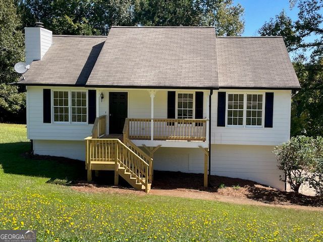 44 Fawn Trl, Hiram, GA 30141 - view of front of property with a porch, a front yard, a chimney, stairway, and roof with shingles