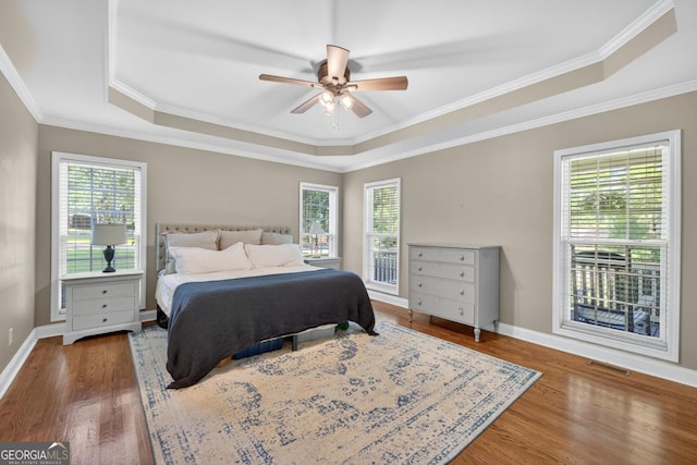 103 W Second St, Greensboro, GA 30642 - bedroom featuring a tray ceiling, wood finished floors, crown molding, and ceiling fan