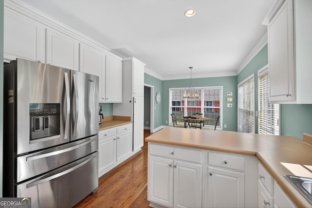 103 W Second St, Greensboro, GA 30642 - kitchen featuring stainless steel fridge, white cabinetry, a chandelier, a peninsula, and ornamental molding