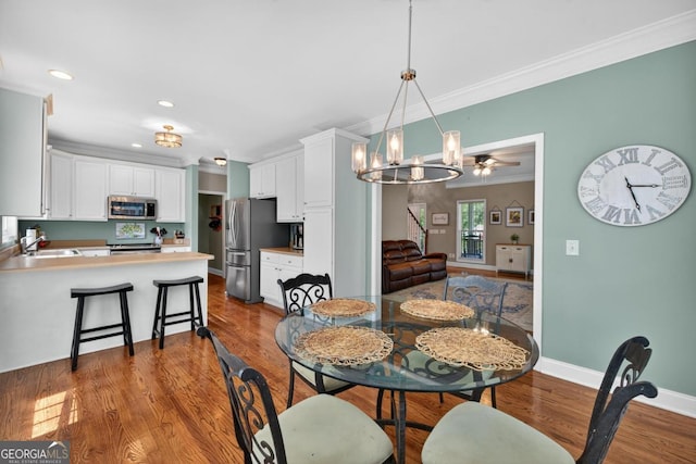 103 W Second St, Greensboro, GA 30642 - dining area featuring ornamental molding, dark wood-style flooring, a chandelier, and recessed lighting