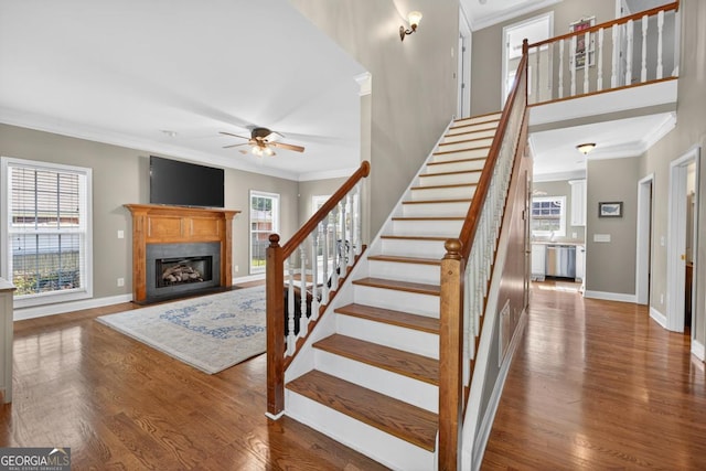 103 W Second St, Greensboro, GA 30642 - stairway featuring crown molding, a ceiling fan, wood finished floors, and a fireplace with flush hearth