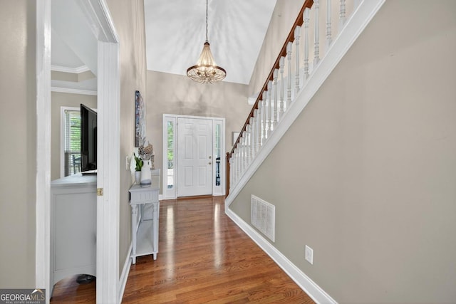 103 W Second St, Greensboro, GA 30642 - entrance foyer featuring a chandelier, ornamental molding, wood finished floors, stairway, and a towering ceiling