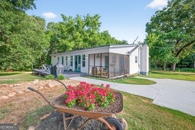 1724 Cedar Grove Church Rd, Winder, GA 30680 - rear view of house featuring a wooden deck, a lawn, and a sunroom