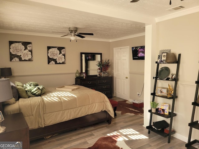 1625 Conley Rd Unit 229, Conley, GA 30288 - bedroom featuring wood finished floors, a textured ceiling, ornamental molding, and a ceiling fan