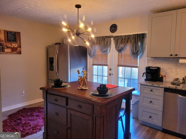 1625 Conley Rd Unit 229, Conley, GA 30288 - kitchen with stainless steel appliances, a chandelier, dark wood-style floors, a textured ceiling, and tasteful backsplash