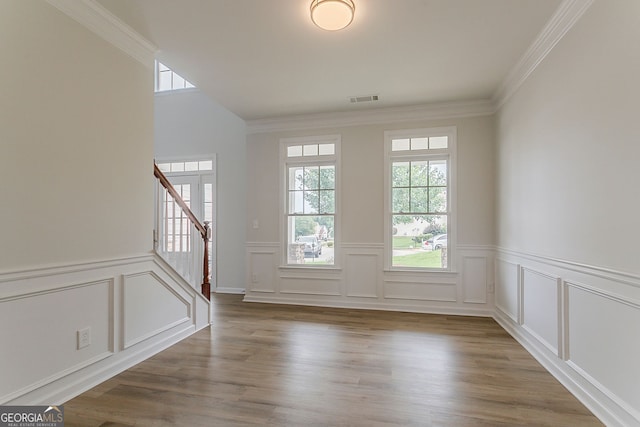 70 Trinity Ln, Covington, GA 30016 - entrance foyer featuring plenty of natural light, a decorative wall, ornamental molding, stairs, and wainscoting