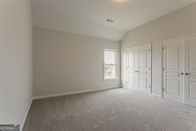 70 Trinity Ln, Covington, GA 30016 - unfurnished bedroom featuring carpet flooring, lofted ceiling, and multiple closets