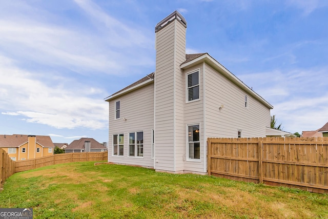 70 Trinity Ln, Covington, GA 30016 - back of house with a fenced backyard and a chimney