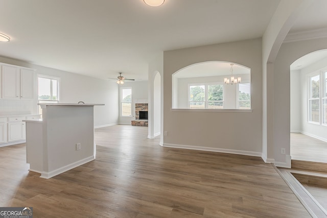 70 Trinity Ln, Covington, GA 30016 - unfurnished living room featuring a fireplace, plenty of natural light, ceiling fan, and wood finished floors