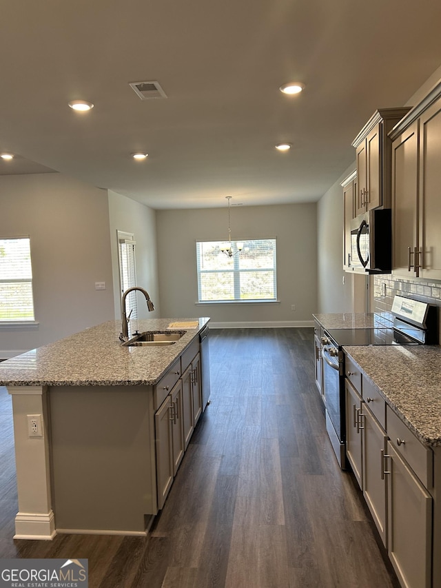 1179 Barrington Place Way, Macon, GA 31220 - kitchen with stainless steel appliances, an island with sink, dark wood-style flooring, light stone counters, and recessed lighting