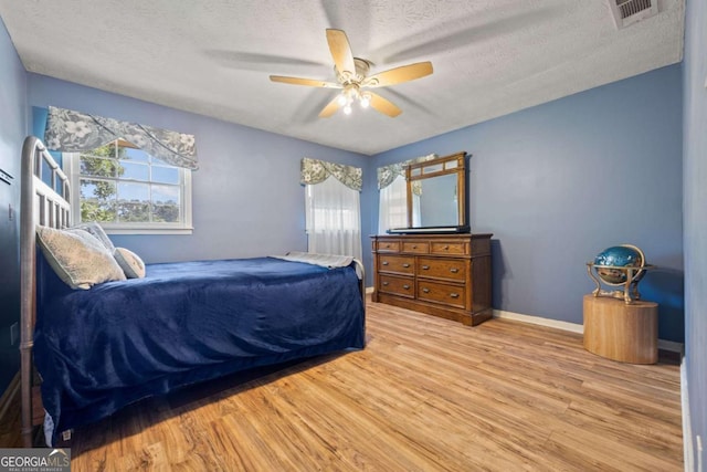 1809 Claron Ave, Conley, GA 30288 - bedroom featuring wood finished floors, multiple windows, a textured ceiling, and a ceiling fan