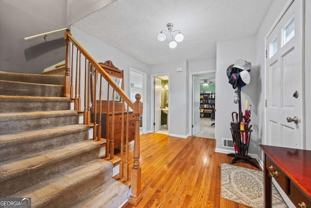 1809 Claron Ave, Conley, GA 30288 - foyer entrance with stairway, light wood-style floors, a textured ceiling, and a chandelier