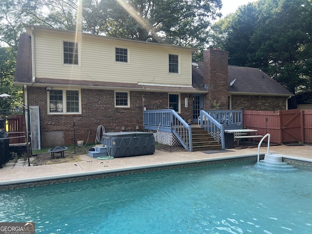 2203 Honeybee Creek Dr, Griffin, GA 30224 - back of property with brick siding, a chimney, an outdoor pool, a deck, and a patio area