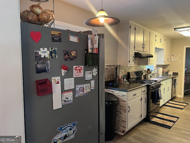 2203 Honeybee Creek Dr, Griffin, GA 30224 - kitchen with stainless steel appliances, under cabinet range hood, decorative backsplash, light wood finished floors, and a textured ceiling