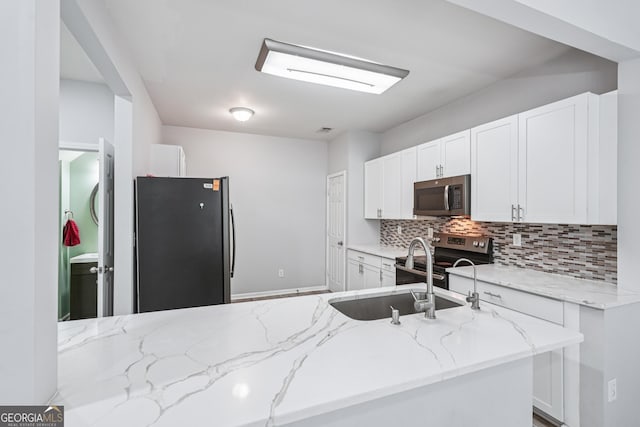 545 Windstone Trl, Alpharetta, GA 30004 - kitchen with stainless steel appliances, tasteful backsplash, light stone countertops, and white cabinetry
