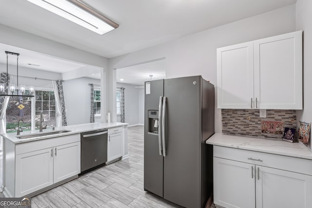 545 Windstone Trl, Alpharetta, GA 30004 - kitchen with stainless steel appliances, white cabinets, tasteful backsplash, light stone counters, and hanging light fixtures