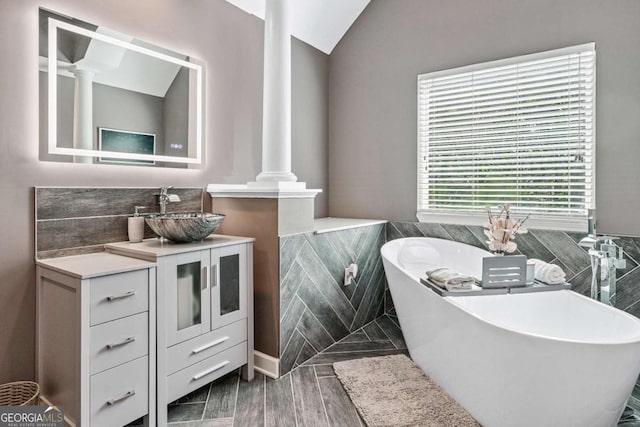 1146 Simonton Peak Way, Lawrenceville, GA 30045 - full bathroom with ornate columns, a freestanding bath, vanity, and tile walls
