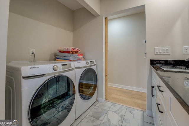 480 Mitchell Rd, Covington, GA 30014 - washroom with independent washer and dryer, light marble finish flooring, and cabinet space