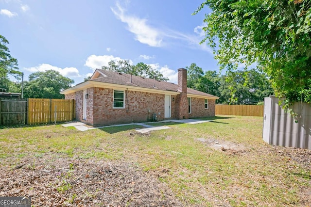 107 Runaway Point Rd, Savannah, GA 31404 - rear view of property featuring brick siding, a fenced backyard, a chimney, and a patio area
