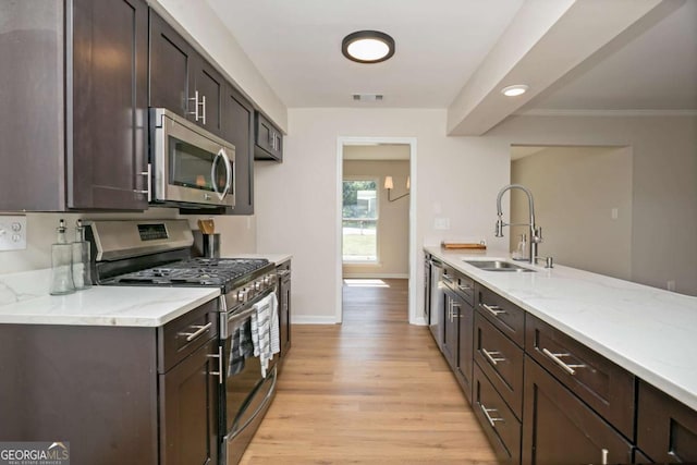 107 Runaway Point Rd, Savannah, GA 31404 - kitchen featuring stainless steel appliances, light wood-type flooring, dark brown cabinetry, light stone counters, and recessed lighting