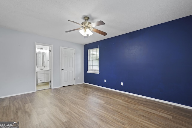 631 Valleybrook Rd, Savannah, GA 31419 - unfurnished bedroom featuring wood finished floors, connected bathroom, a textured ceiling, and a ceiling fan