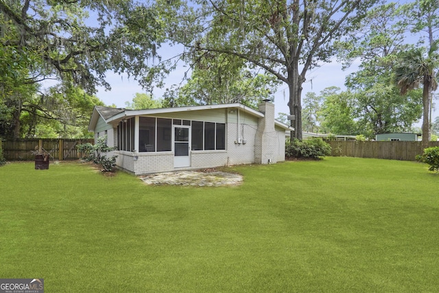 631 Valleybrook Rd, Savannah, GA 31419 - back of house featuring a chimney, a sunroom, a fenced backyard, and brick siding