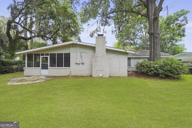 631 Valleybrook Rd, Savannah, GA 31419 - back of house featuring brick siding, a chimney, and a lawn