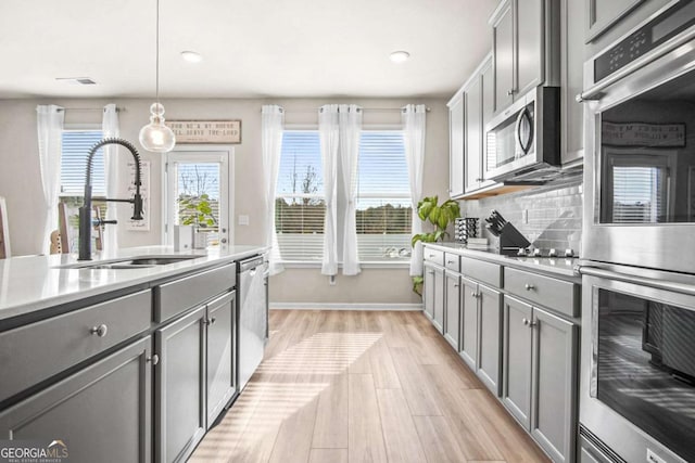 1049 Bodega Loop, Locust Grove, GA 30248 - kitchen featuring stainless steel appliances, gray cabinetry, light countertops, light wood finished floors, and recessed lighting