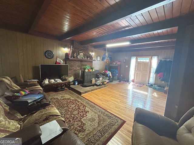 1551 Vaughn Rd, Griffin, GA 30223 - living room featuring wooden walls, wood finished floors, a wooden ceiling with exposed beams, and a wood stove