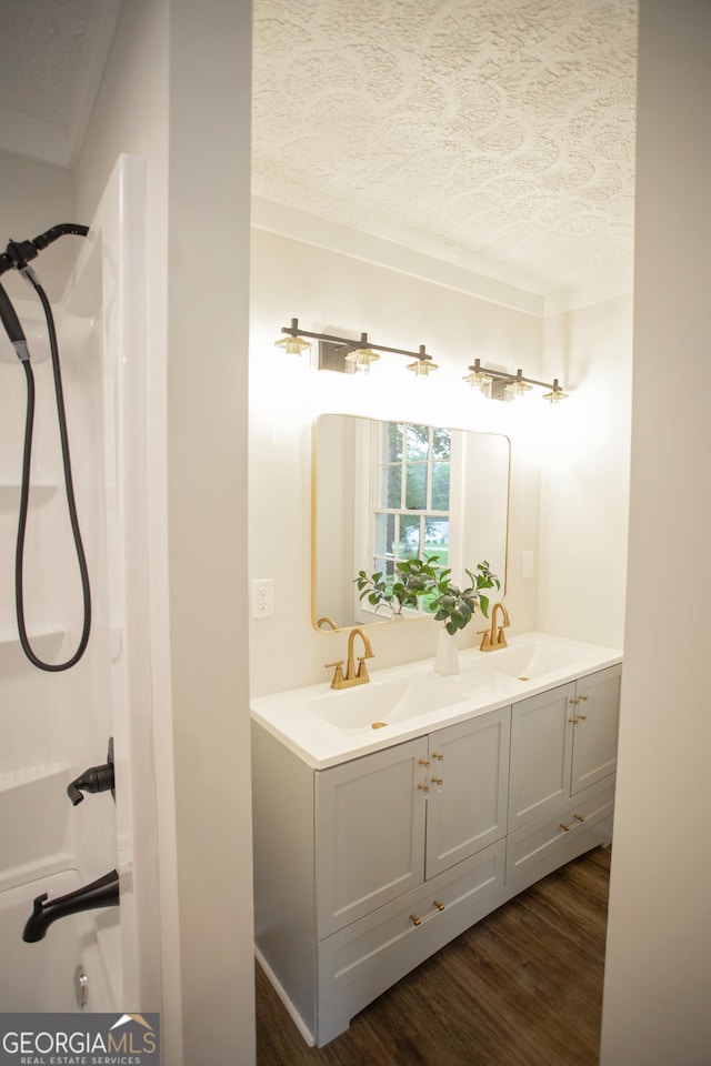 235 Cindy St, Jackson, GA 30233 - bathroom with wood finished floors, a textured ceiling, and double vanity