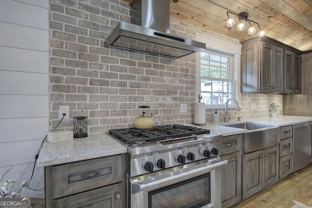 198 Hillcrest Dr, Calhoun, GA 30701 - kitchen with wall chimney range hood, appliances with stainless steel finishes, tasteful backsplash, light wood finished floors, and light stone counters
