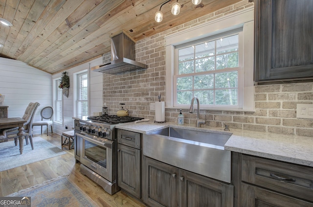 198 Hillcrest Dr, Calhoun, GA 30701 - kitchen with high end stainless steel range oven, wall chimney exhaust hood, lofted ceiling, backsplash, and light wood-style flooring